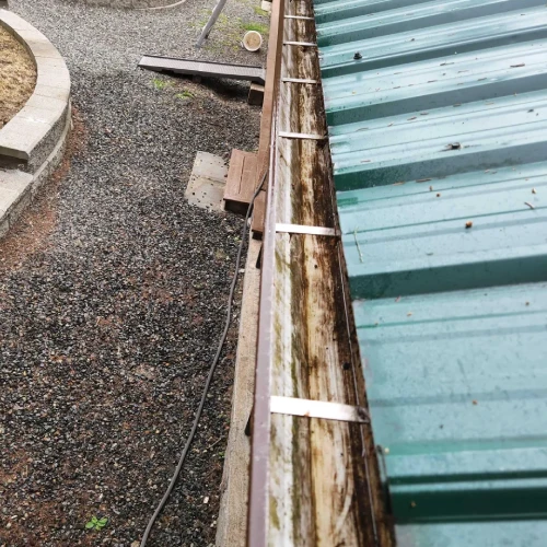A gutter that has been cleaned and is being worked on.